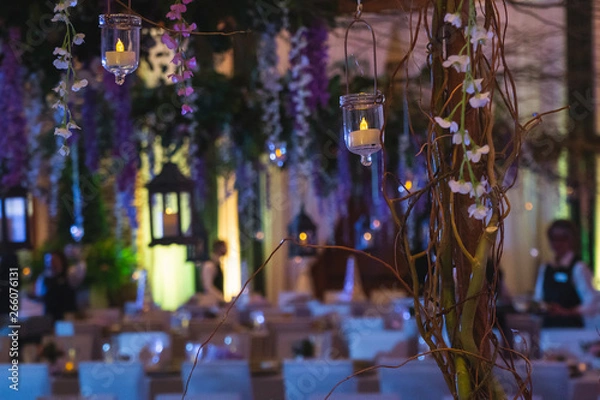 Fototapeta Vines with Hanging Lanterns Floating over an Elegant Dinner event.