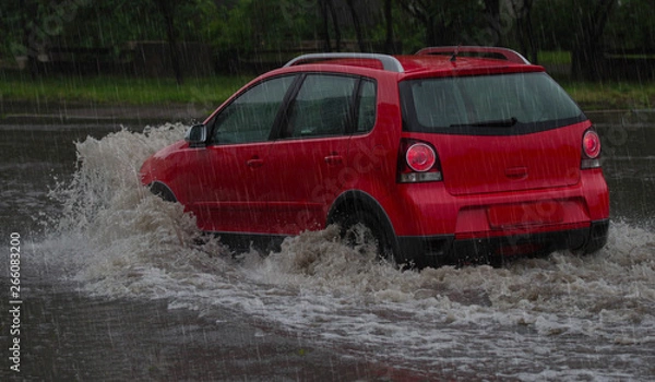 Obraz car rides in heavy rain on a flooded road