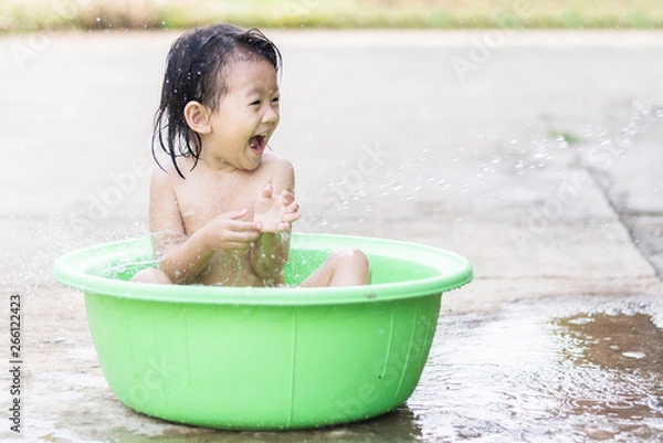 Fototapeta little children sit in basin and had fun playing water
