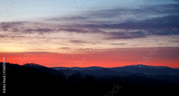 Fototapeta colorful sunset with glowing clouds and a tree a hill and valley silhouette in the austrian alps