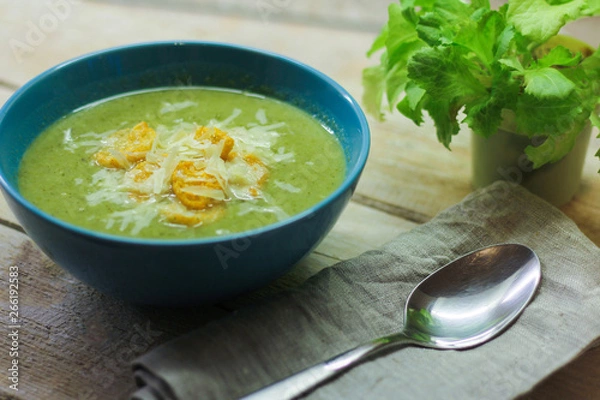 Fototapeta fresh mashed soup with broccoli and green beans in a blue plate on a wooden background