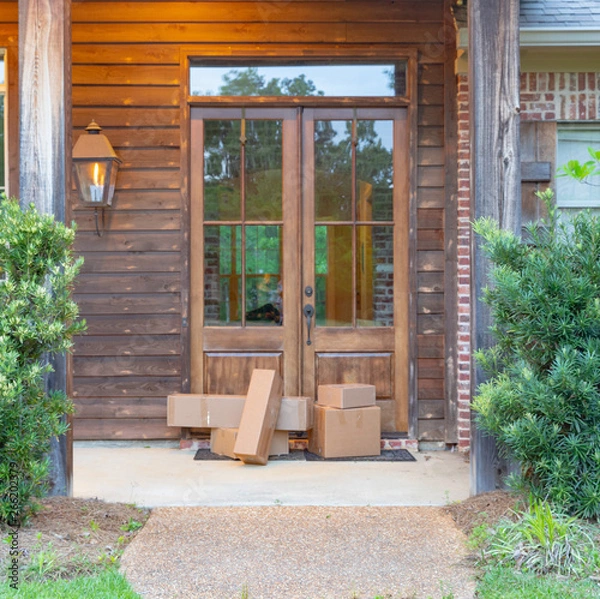 Fototapeta Shipping Packages on front porch of house, in front of the door.