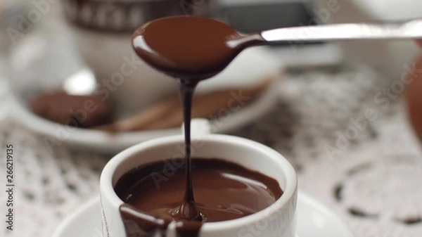 Obraz hand mixing chocolate in a hot milk, preparing hot chocolate or cacao, bautiful soft focus shot