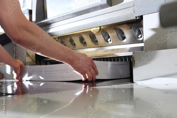 Fototapeta Bindery. Paper trimming on a guillotine. Cutter for cutting paper. Printing house.