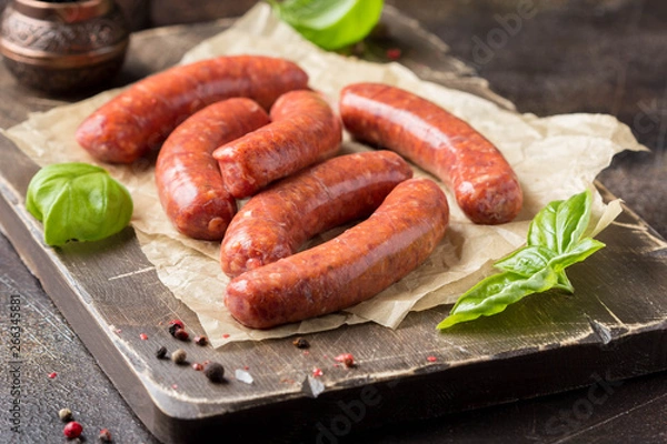 Obraz Raw grilled sausages with meat (beef, pork, lamb) and spices, hot merguez, kabanos, chorizo. Delicious food for picnic