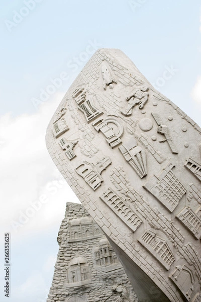 Fototapeta A sculpture showing various things under a blue cloudy sky