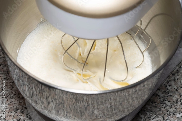 Fototapeta The process of whipping of batter in a planetary mixer. Selective focus.