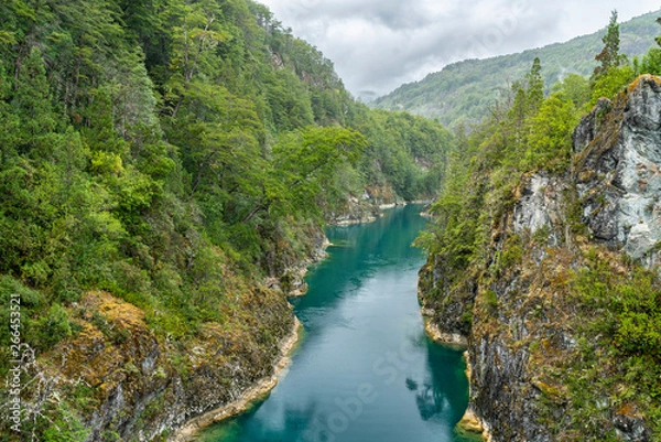 Fototapeta An amazing landscape at north Chilean Patagonia, Puelo river moves around the narrow gorge with its turquoise waters on an awe idyllic natural environment outdoor rugged landscape under a dramatic sky