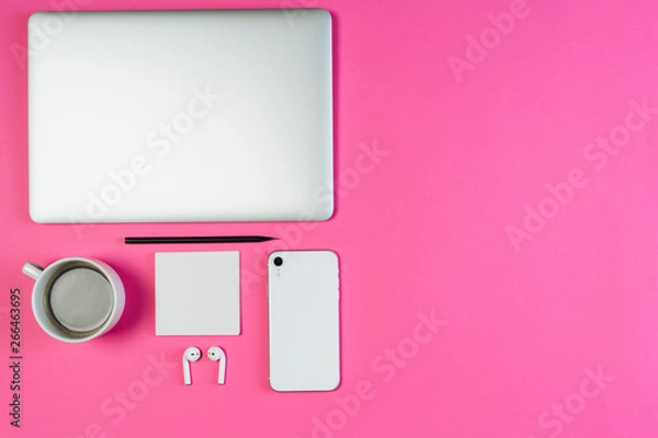 Fototapeta Laptop Phone Coffee on Pink Workspace Flat Lay with Copy Space. White Smartphone, Earphone and Pencil on Minimal Clear Layout Background with Paper Note. Business Workspace Order Inspiration Concept