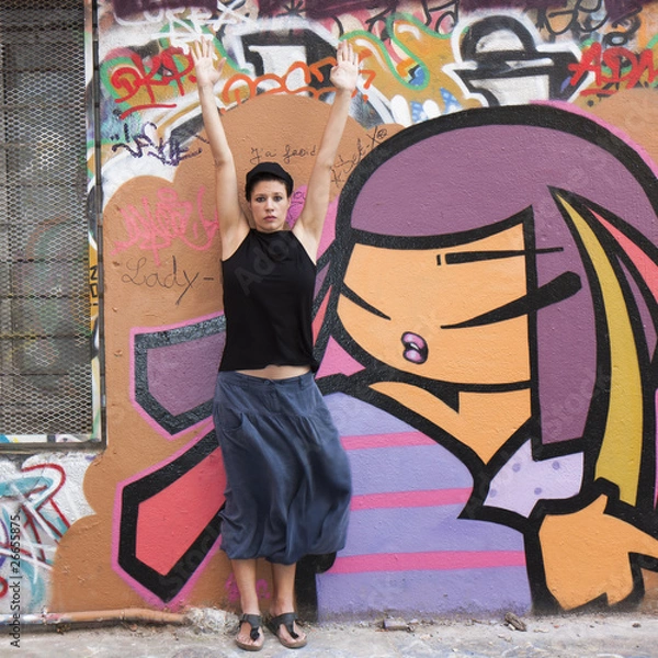Obraz Jeune femme faisant sa gymnastique devant un graffiti