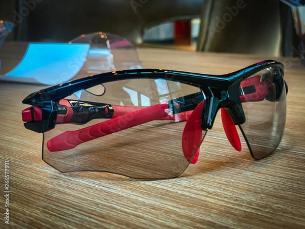 Fototapeta Black and red sunglasses Placed on the table blurry background