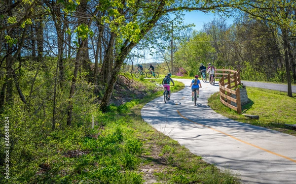 Fototapeta Rodzina z dziećmi na rowerze na szlaku rowerowym w Bella Vista w północno-zachodnim Arkansas