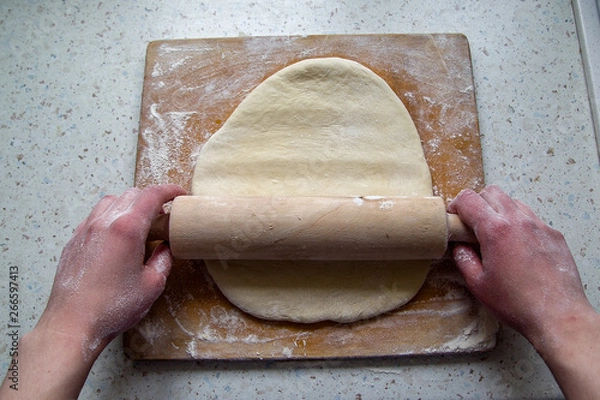 Obraz Woman's hands roll the dough. First-person view