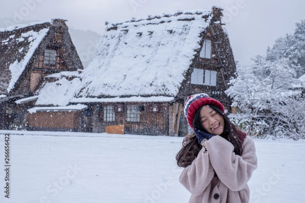 Obraz Shirakawa-go village in winter with Happy Asia Girl including copy space on traditional House Gassho style, one of UNESCO world heritage sites, Gifu, Japan. Background texture of traveling spectacular
