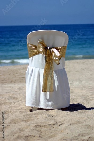 Obraz white chair with gold ribbon for a beach wedding