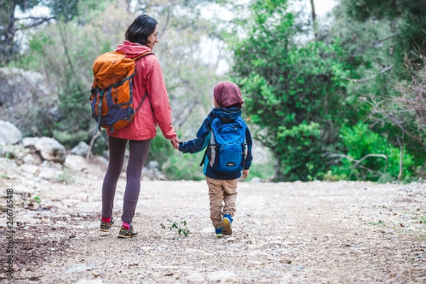Fototapeta A woman walks with her son through the forest.