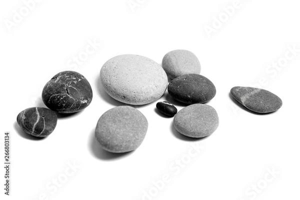 Fototapeta Scattered sea pebbles. Heap of smooth gray and black stones isolated on white background
