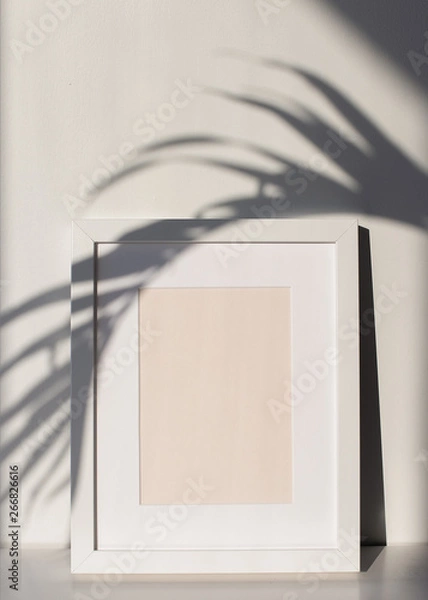 Fototapeta White Picture Frame with Matting on a Shelf with a Palm Tree Leaf Shadow, White Background. Poster and Print Design Photo Mock-Up, Blank and Empty Frame - 12x16 inches, 8x10 inches or Similar Ratio