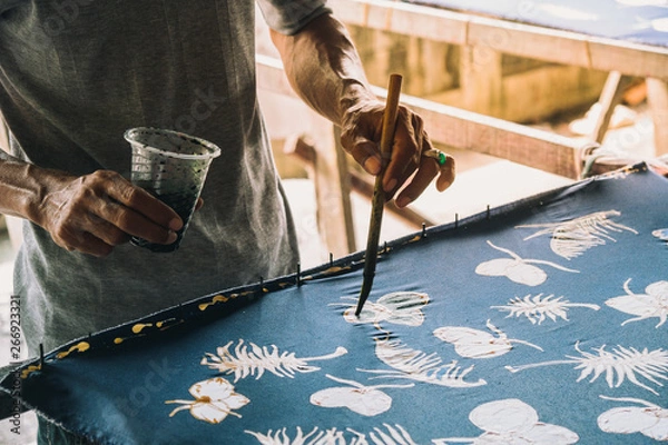 Fototapeta The close-up hand of  artist is painted on the fabric