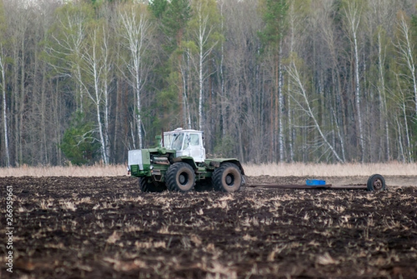Obraz  The tractor handles the soil. Spring field work.