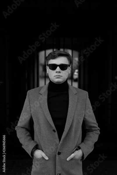 Obraz Black and white portrait of man with smart casual style. Sunglasses, polo neck and elegant jacket.