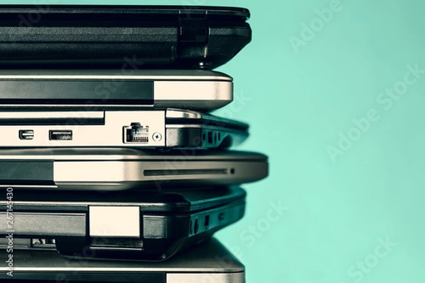 Obraz Stack of laptops / notebooks on turquoise background with copy space