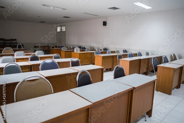 Fototapeta Education concept: Empty college or university classroom with wooden tables and chairs in row without student or teacher in the room. School classroom with window opened, clean and tidy ready for new 