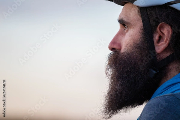 Fototapeta Young caucasian bearded man wearing a bike helmet