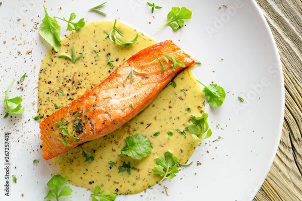Fototapeta fried salmon with fresh garden cress, thyme, rosemary and dry spices in lemon-mustard sauce 