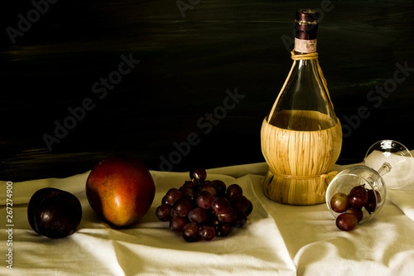 Fototapeta Artistic Lighting on Wine Bottle with Mango and Grapes and Plum on Dark BG with Copy Space