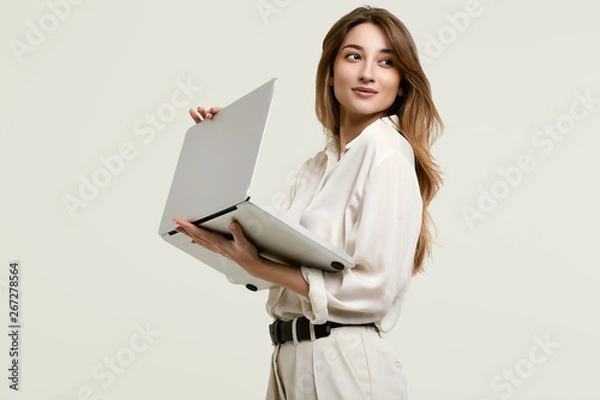 Obraz Gorgeous brunette model posing in white clothes with laptop