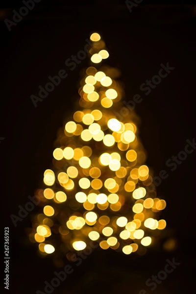 Fototapeta Golden Christmas tree with decorations and lights bokeh in a black background
