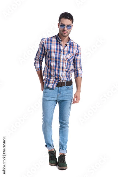 Fototapeta Confident looking guy stepping and reaching for his back pocket