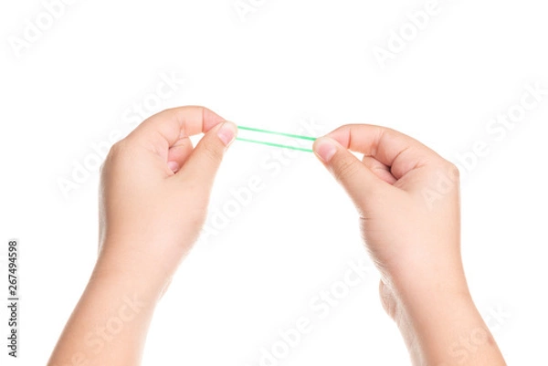 Fototapeta Child hand playing with elastic rubber band isolated on white