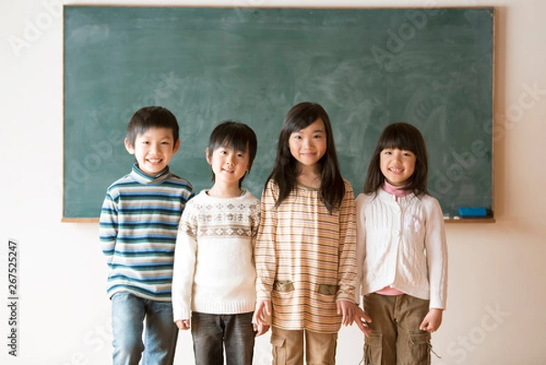 Obraz 黒板の前で微笑む小学生