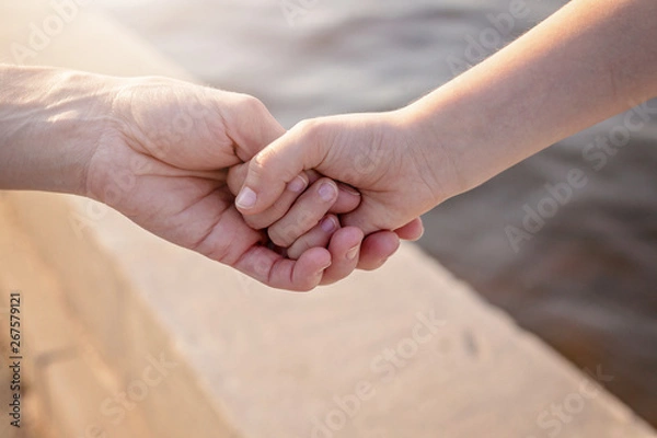 Fototapeta Mom holds her daughter's hand. Happy family concept