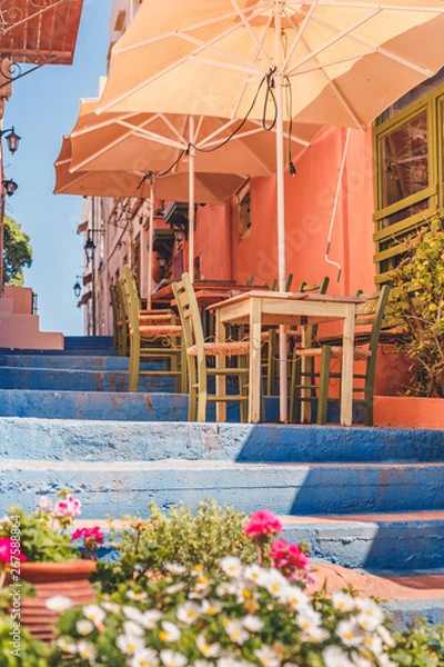 Fototapeta Tables and chairs outside on a stairway in a little coastal town near the sea