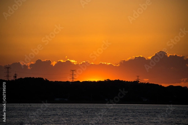 Obraz 地平線の雲のかなたに沈む夕日の残照