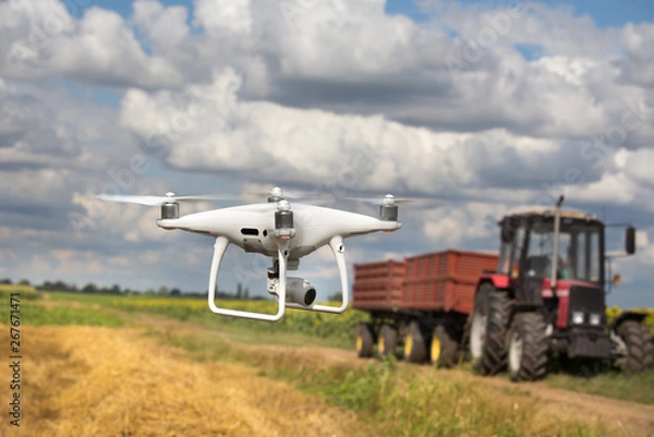 Obraz Drone in front of tractor in field