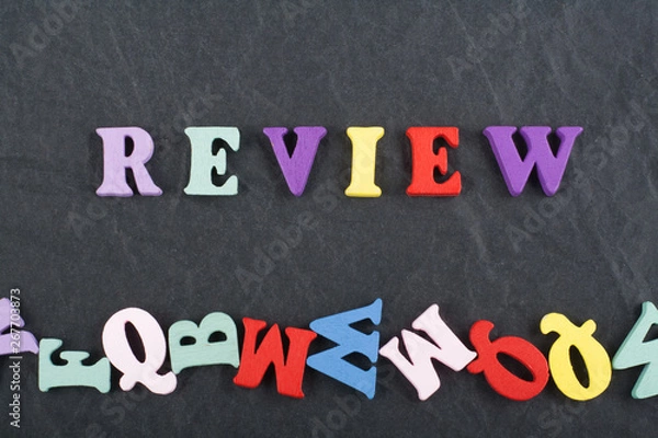 Fototapeta REVENUE word on black board background composed from colorful abc alphabet block wooden letters, copy space for ad text. Learning english concept.