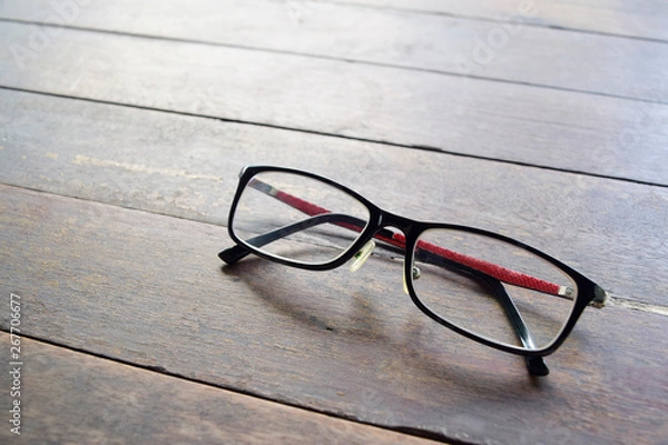Fototapeta Glasses on dark wood desk.