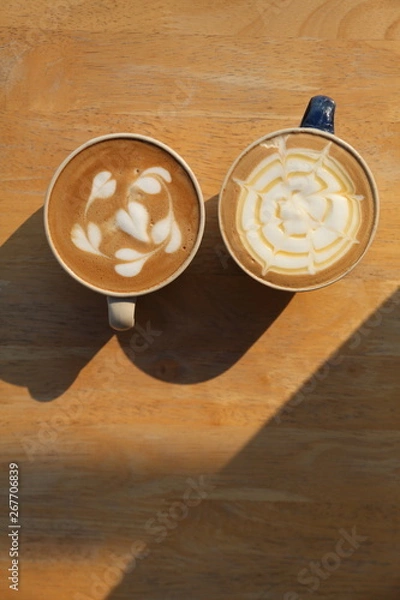 Obraz Two cup of different coffee which are cappuccino and caramel latte milk  on the wooden rustic table in the morning with strong light and shadow with copy space
