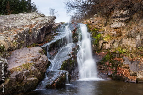 Obraz Gorgeous mountain creek waterfall cascading down the rocky cliff and colorful autumn red leaves