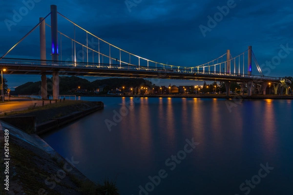 Fototapeta The first suspension bridge in Belgium located in Kanne with a span of 120 against a dramatic evening sky during twilight