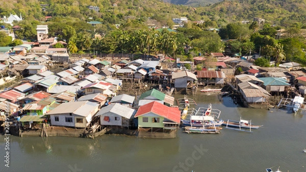Fototapeta Aerial view Coron city with slums and poor district. Palawan.Wooden houses near the water.Poor neighborhoods and slums in the city of Coron aerial view