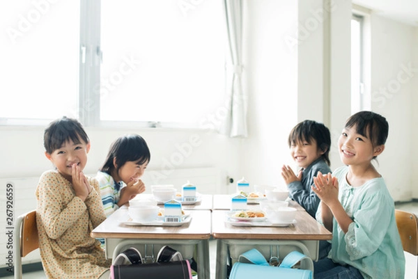 Obraz 給食を前に手を合わせる小学生