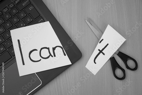 Obraz I can, I can't. White paper, notebook and scissors on a desk with a message I can