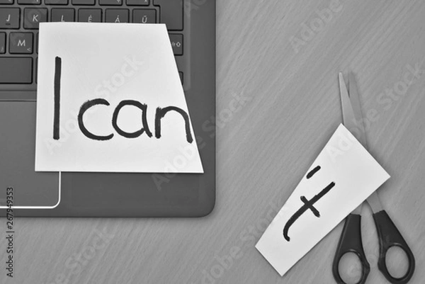 Obraz I can, I can't. White paper, notebook and scissors on a desk with a message I can