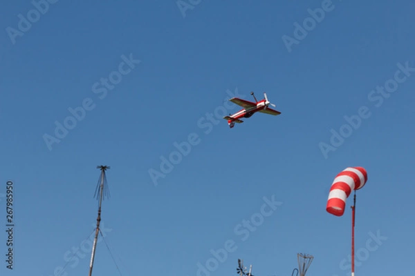 Fototapeta Condensation trace highlighted by the setting sun behind a plane in the blue sky. Condensation track the outdated inversion trail