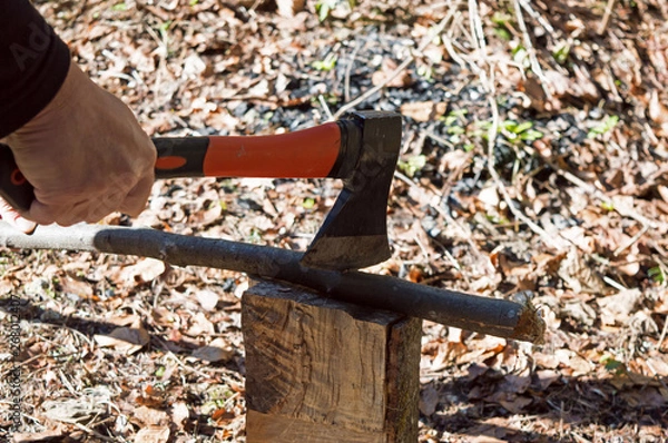 Obraz Close-up Man's Hand Cuts Wooden Stick With An Ax